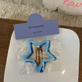 Dettaglio di fermagli per capelli a forma di stella blu con clip in metallo dorato - Serie Blu
