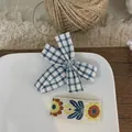 Gros plan sur le nœud à carreaux bleus et la barrette avec broderie de tournesol - Nœud Plaid Et Floral