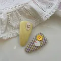 Détail de pince à cheveux en tricot jaune avec chien ballon et nœud à carreaux sur dentelle - Bouton Plaid Triangle Jaune