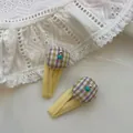 Détail de deux pinces BB en tissu jaune avec coussinets à carreaux et perles bleues - Rembourré Plaid Jaune