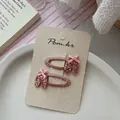 Detail of pink ballet shoe hair clips with glitter coating and silk bows on card - Pink Ballet Shoes