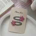 Vue détaillée des barrettes à cheveux étoile rose pailletée et anneau tissé sarcelle - Étoile Rose