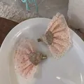 Dettaglio di fermagli in tulle rosa con cuore dorato e paillettes su un piatto bianco - Coppia Cuore Rosa Chiaro Glitter