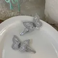 Detailed view of silver sequin butterfly hair clips on a white ceramic plate - Silver Butterfly Hair Clip