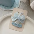 Gros plan détaillé de pinces à cheveux en dentelle bleu clair et ruban texturé sur carte - 蝴蝶结+亮片水滴发夹