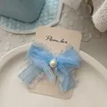 Dettaglio di fermaglio per capelli a fiocco in organza blu con perla su cartoncino - 纱质蝴蝶结发夹