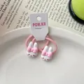 Gedetailleerde weergave van roze konijnenhaarelastiekjes met witte bedeltjes van hars - Rabbit Hair Tie / Roze