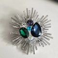 Macro shot of sunburst brooch featuring blue teardrop crystal and emerald green gemstones - 6.0*6.0CM / Silver