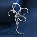 Elegante broche de lazo plateado con circonitas sobre fondo de terciopelo azul marino de alta gama - Silver Ribbon Style / Cinta Plateada