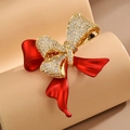 Bow brooch with red matte ribbon and gold crystals on a neutral background - Red