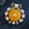 Elegante spilla di perle e ambra con fiocco dorato e simbolo portafortuna cinese - Nastro Perla Cera d'Api