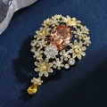Elegante broche de flor vintage con cristales champán y acabado dorado sobre azul - Champán