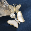 Elegante spilla a farfalla con ali in madreperla e perle su una montatura dorata - Farfalla in Conchiglia