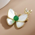 Eleganter Schmetterling-Brosche mit weißem Perlmutt und grünem Perlenakzent auf Gold - Weiß