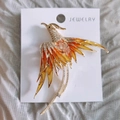 Golden phoenix brooch with orange enamel wings and sparkling rhinestones on jewelry card - Yellow