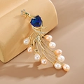 Elegant peacock brooch with heart-shaped blue gemstone and freshwater pearls decor - Blue