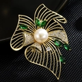 Macro di una spilla a fiore con smeraldo di lusso, perla bianca e petali d'oro - Rame Zircone Perla / Verde Smeraldo