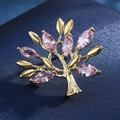 Detailed view of pink marquise gems and golden tree brooch on deep blue fabric - 7-Small Tree