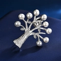 Macro shot of tree-shaped brooch with silver branches and nine white pearls on blue silk - Silver Pearl Tree of Life Shape / Pearl Christmas Tree