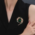 Spilla elegante dorata con goccia di cristallo verde scuro su sfondo in tessuto nero - Cristallo Verde Zirconia Rame
