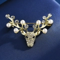 Vue détaillée d'une broche renne avec perles et strass sur un tissu bleu - Tête de Cerf