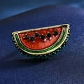 Macro shot of watermelon brooch with red glaze, black rhinestones, and gold metal trim - 12-Watermelon