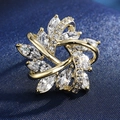 Close-up of a gold starburst brooch with marquise-cut and round clear cubic zirconia stones - 15-Five-pointed Star Spiral