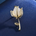 Macro detail of a gold rose brooch featuring an opal stone and sparkling zircon accents - 3-Cat's Eye Rose