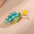 Detailopname van een bladvormige broche met groen emaille en glanzende zirkoniasteentjes - Smaragdgroen