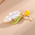 Elegante gouden bladbroche met wit parelmoer inlegwerk en groene zirkoonaccenten - Wit