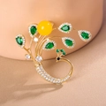 Macro shot of peacock brooch with gold finish, green gemstones and white zircon stones - Radiant Phoenix