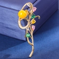 Makroaufnahme einer Orchideenbrosche mit bunten Steinen auf einer Schmuckbox - Gelber Achat Perle Stil / Gelb