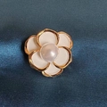 Dettaglio della spilla a camelia con petali in smalto bianco e perla centrale - Avorio