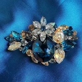 Elegant vintage crystal flower brooch featuring a large navy blue centerpiece stone - Blue
