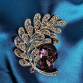 Detailansicht einer Vintage-Blattbrosche mit lila Kristall und Zirkonia-Besatz - Burgunderrot