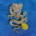 Exquisite gold dragon brooch with sparkling white crystals and amber bead on blue fabric - Dragon With Bead