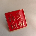 Close-up of red enamel badge with gold metallic border and Chi Zhi Yi Heng inscription - Persistent (Square)