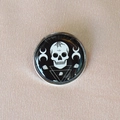 Close-up of a Gothic enamel brooch featuring a skull, spiderweb, and moon symbols - Black