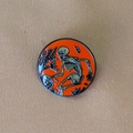Detail of Halloween enamel pin showing a skull in a cemetery on an orange background - Skeleton Mining