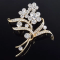 Elegante spilla a fiore dorata con cristalli scintillanti su superficie nera lucida - Stile Floreale Freesia (xz0146)