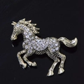 Elegante spilla a forma di cavallo dorato con cristalli scintillanti su fondo nero - Bianco