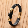 Detail of woven black leather bracelet featuring gold charms and a clover flower charm - Gold-E