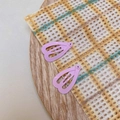 Macro detail of two lavender heart-shaped snap clips on a cozy textured fabric background - Light Purple