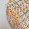 Detail shot of two orange heart-shaped matte finish mini BB hair clips on wooden tray - Orange