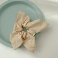 Beige oversized fabric bow scrunchie with natural cotton linen texture on tray - Khaki