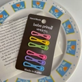 Detail of 6 matte colorful hair clips on cardstock over a tulip decorative plate - Candy Color Bow Duckbill Clip