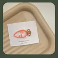 Detailansicht einer hellorangen Haarklammer in Karottenform auf einer Displaykarte - Hohle Karotte Stil (Mit Karte) / Hellorange
