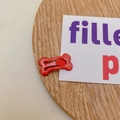 Fermaglio rosso glitterato a forma di osso per animali o bambini su piatto di legno - Rosso