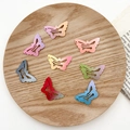 Achtstuks vlinder haarclips set met kleurverloop en matte lak op een houten plateau - Kleine Vlinder