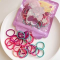 Macro shot of colorful elastic baby hair ties spilling from cartoon pouch into white bowl - Dual Multi-Color Style (16) / Splice Style